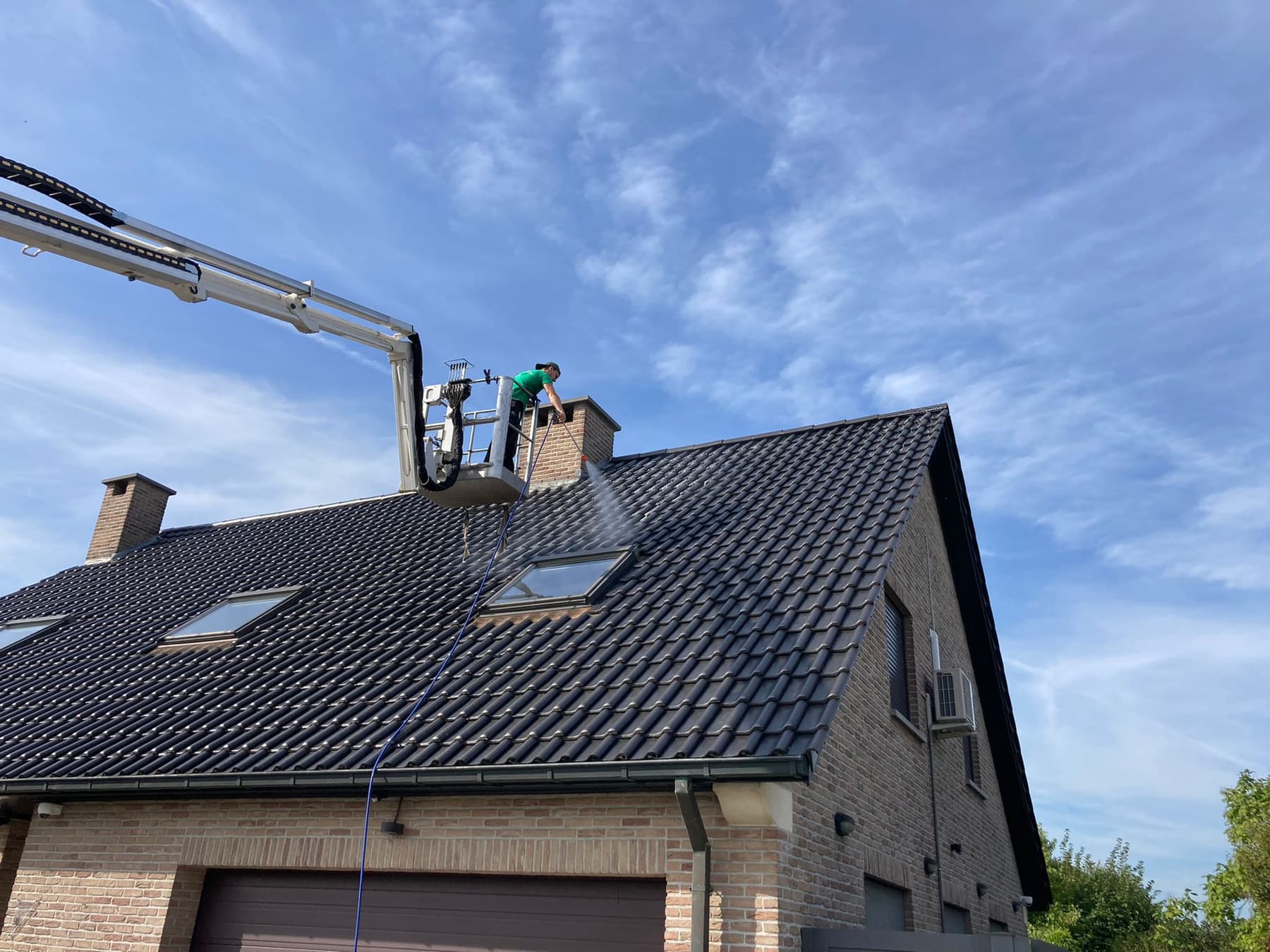 Hoogtewerker van Eco-Steam boven een pannendak
