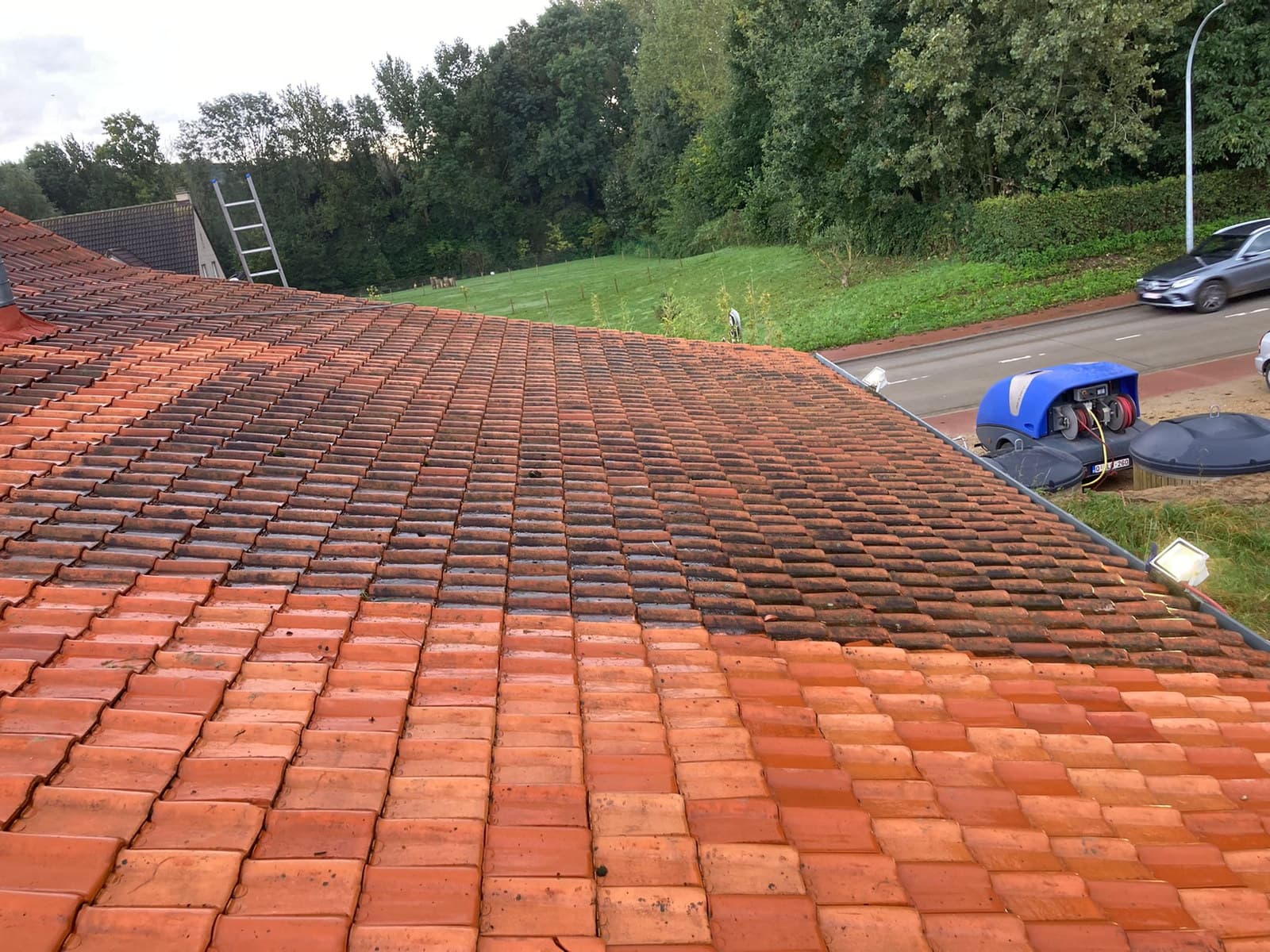 Woning met gereinigd pannendak en hoogtewerker op de oprit