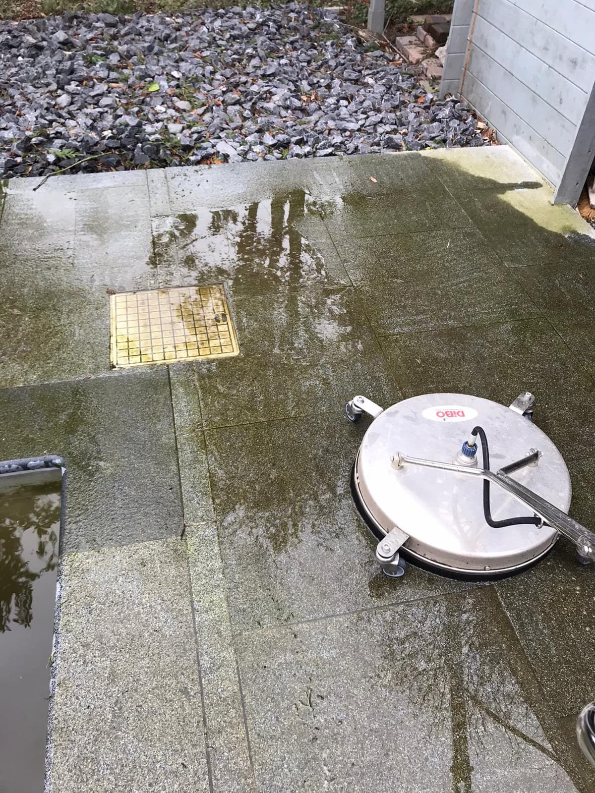 Vlakreiniger op terrastegels met groene aanslag