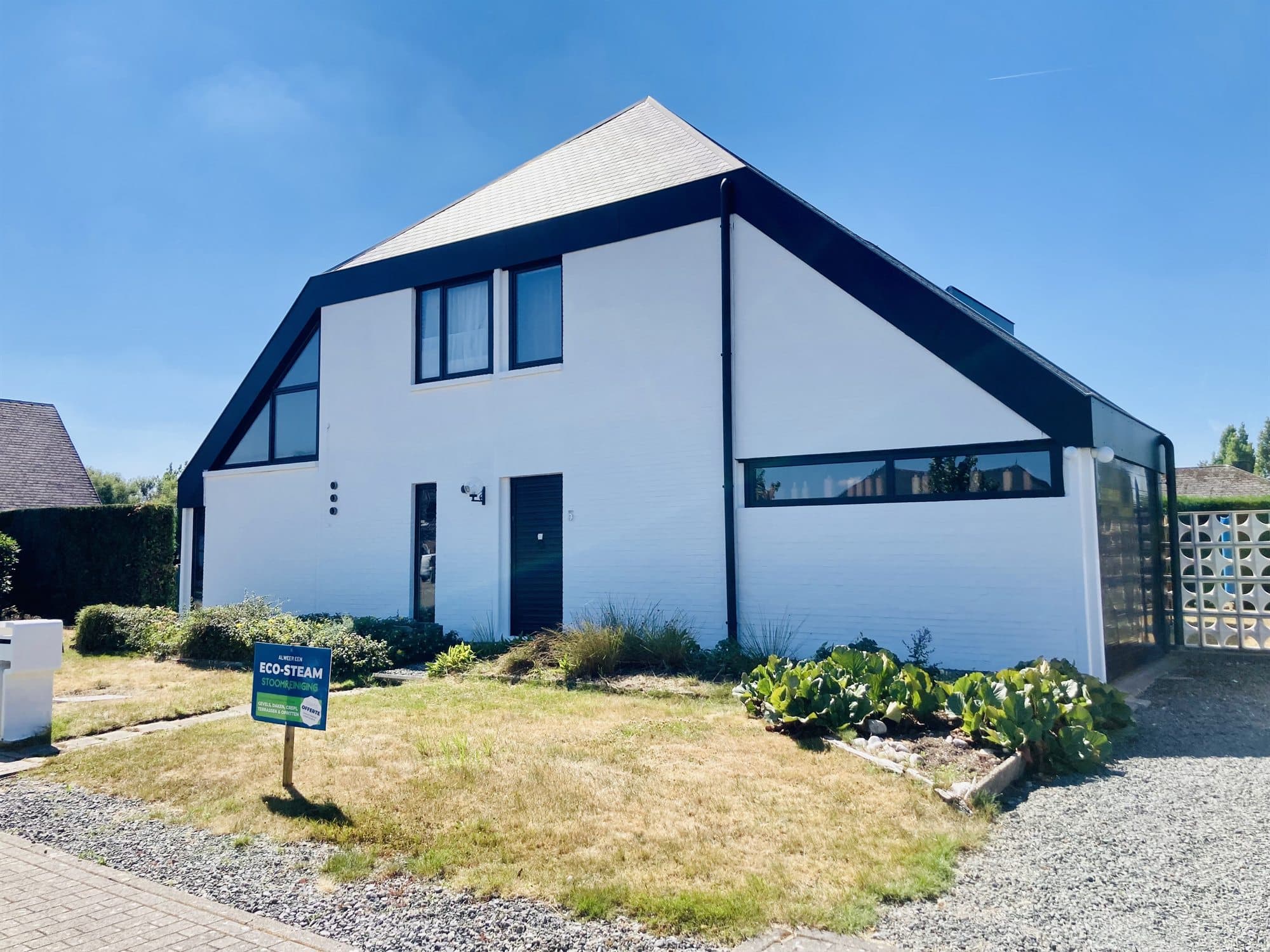 Witte woning met zwarte gevelaccenten na reiniging