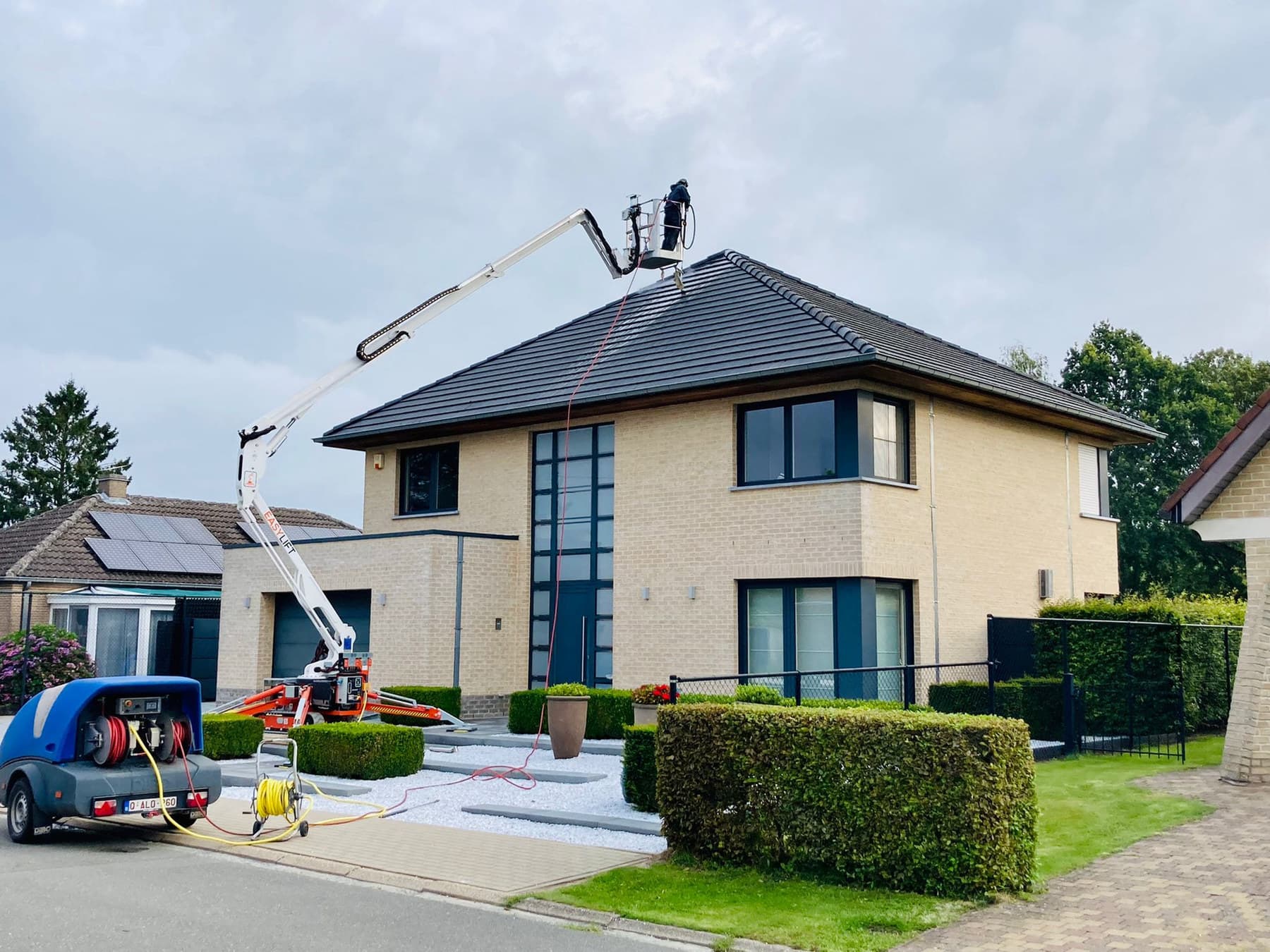 Hoogtewerker van Eco-Steam bij een vrijstaande woning tijdens een dakreiniging
