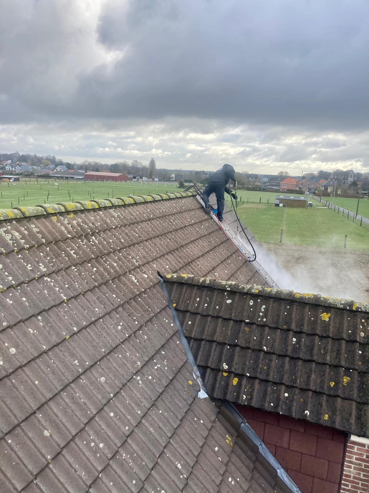 Vakman van Eco-Steam reinigt een pannendak met stoom