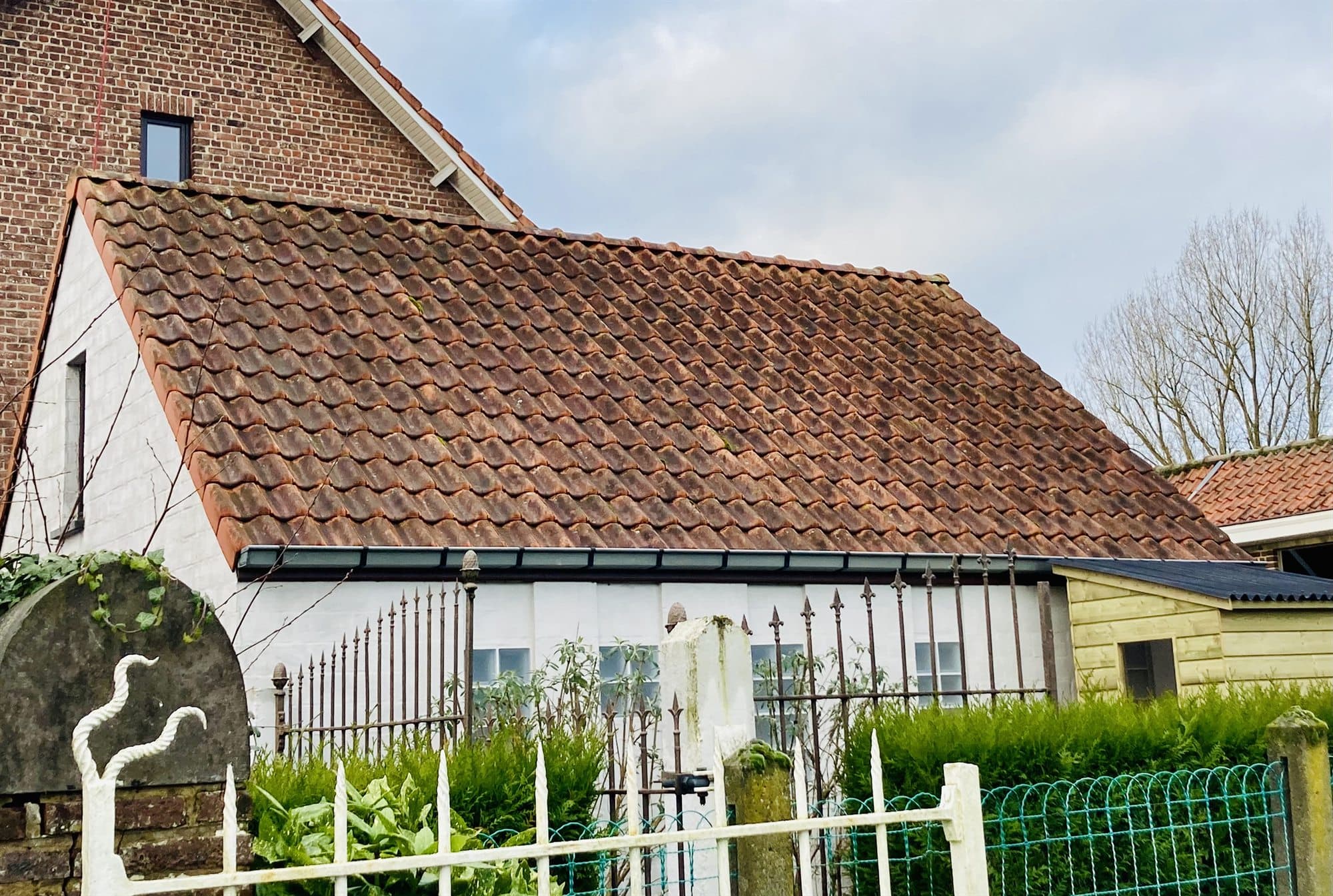 Hoeve met een vergrijsd, vermost pannendak